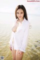 A woman in a white shirt standing in the water.